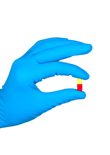 Hand i blå Gummihandske innehar burk piller isolerade. — Stockfoto