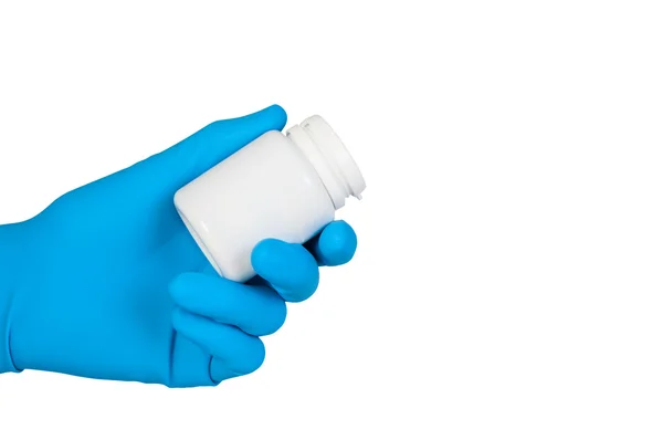 V modré gumové rukavice drží sklenici prášků, samostatný. — Stock fotografie