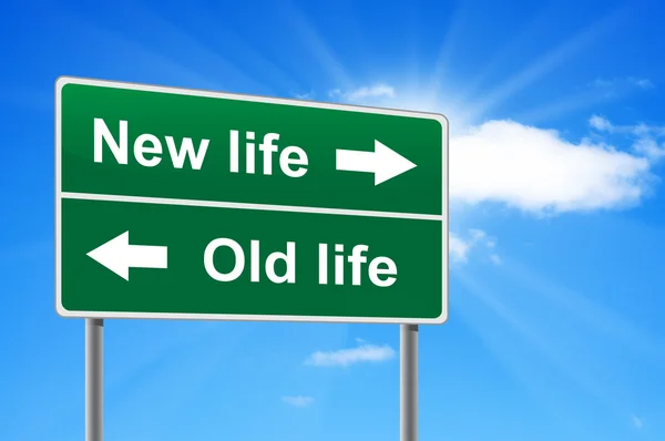 New life old life road sign on background clouds and sunburst. — Stockfoto