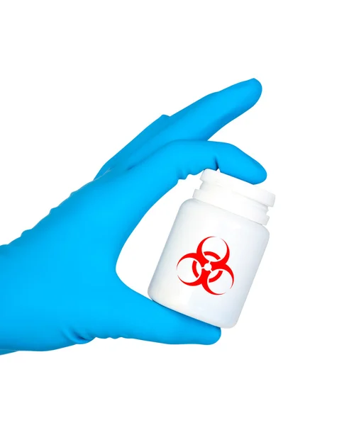 Hand holds jar of medicament with symbol biohazard. — Stock Photo, Image