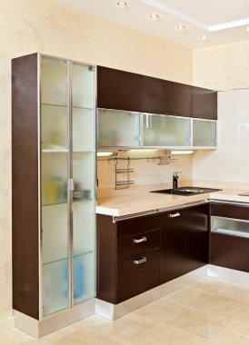 Part of modern Kitchen interior with cupboard in warm tones clipart