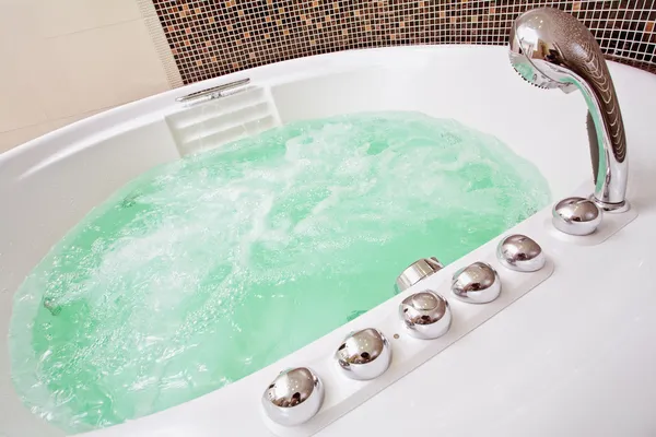 Джакузи с вихревой водой и коричневой мозаикой в ванной комнате — стоковое фото