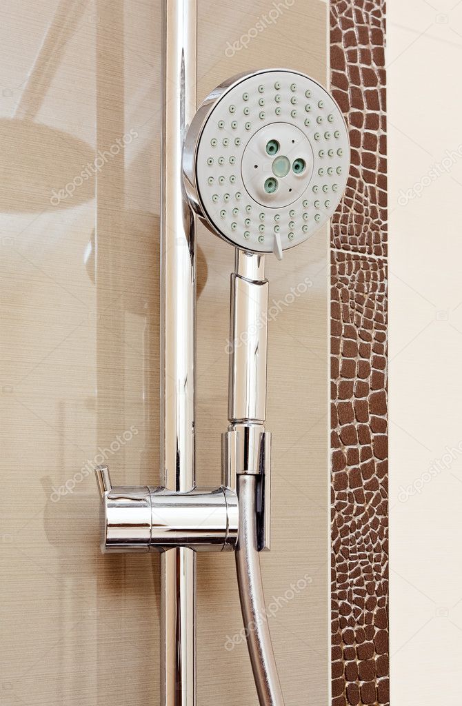 Metal shower tap in modern bathroom with brown ceramics tile