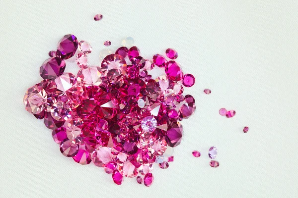 Piedras de diamante (rubí) amontonadas sobre fondo de tela de seda crema — Foto de Stock