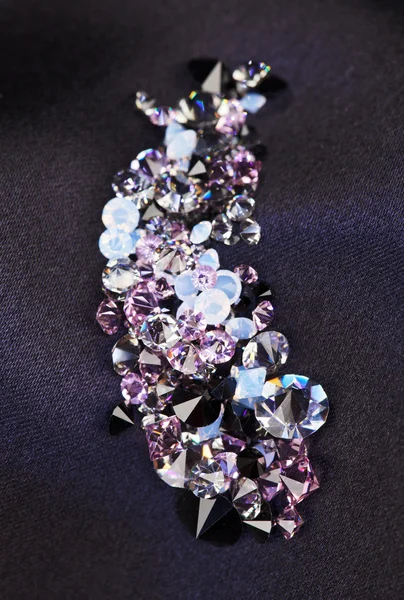 Бриллиантовый (маленький фиолетовый драгоценный камень) камни кучи на черной шелковой ткани б — стоковое фото