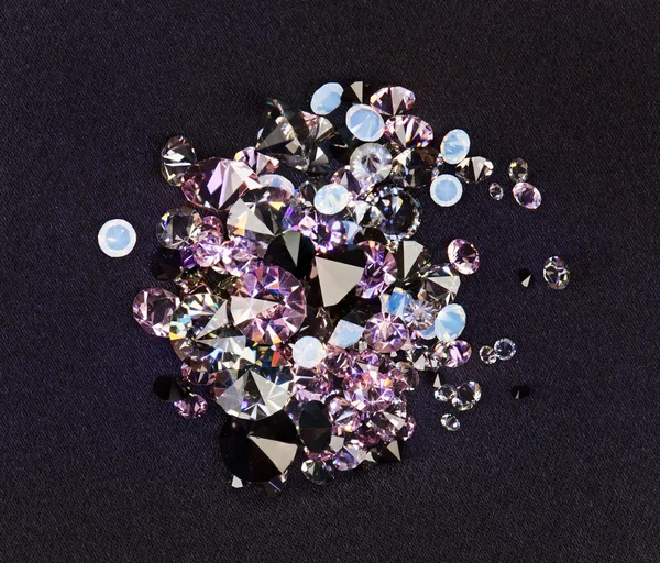 Diamant (kleiner lila Juwel) Steine häufen sich über schwarzem Seidentuch — Stockfoto