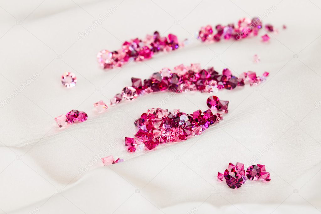 Diamond (ruby) stones heap over cream silk cloth background
