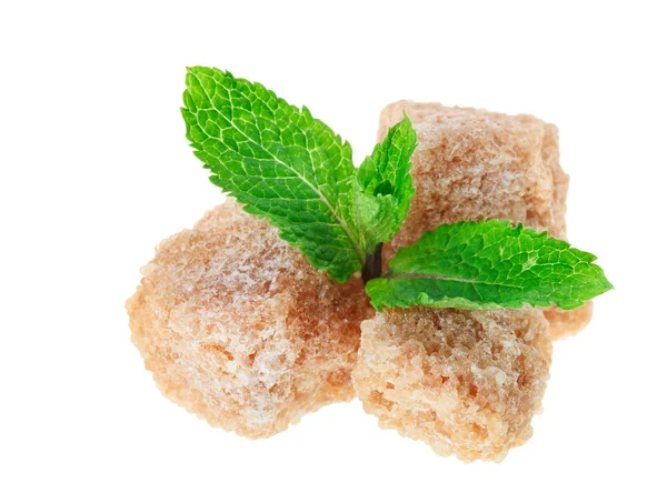 Three brown lump cane sugar cubes with peppermint leaves, isolat — Stock Photo, Image