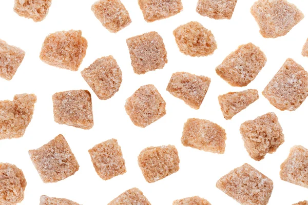 Muitos cubos de açúcar de cana-de-açúcar de caroço marrom isolado em branco, backgro comida — Fotografia de Stock