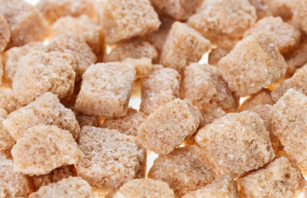 Molti cubetti di zucchero di canna grumo marrone, sfondo cibo — Foto Stock