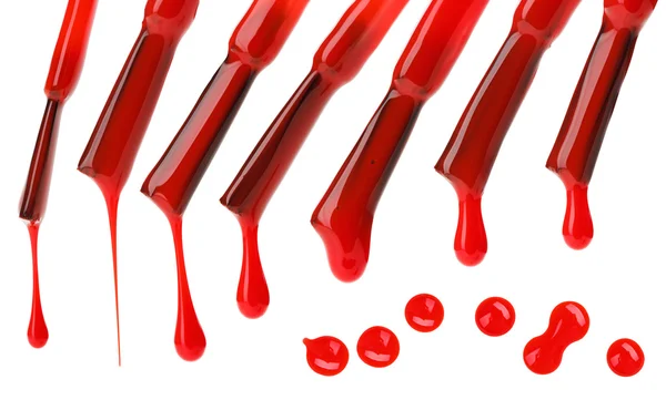 Set di pennelli e gocce di smalto rosso isolati su bianco — Foto Stock