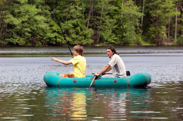 De vader en de zoon vissen met een boot — Stockfoto