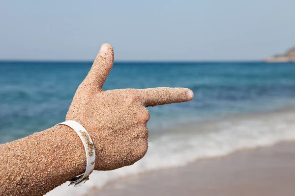 Hand forefinger pointing sea beach — Stock Photo, Image