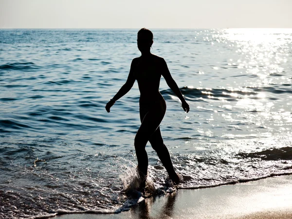 Stock image Woman silhouette on sea beach