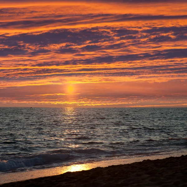 海砂のビーチで雲の空の夕焼け — Stock fotografie