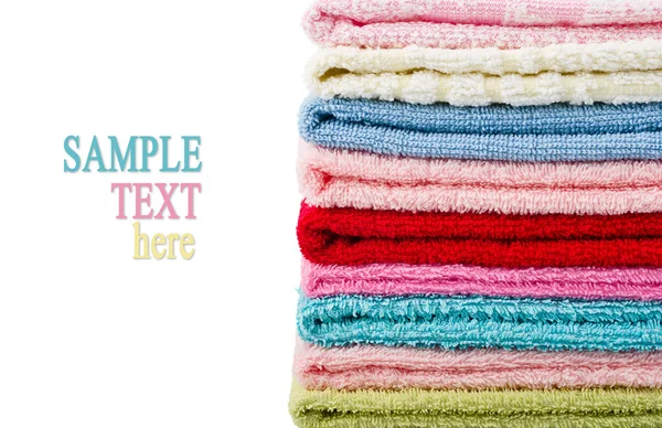 Högen staplade färgglada handdukar isolerad med exempeltext — Stockfoto