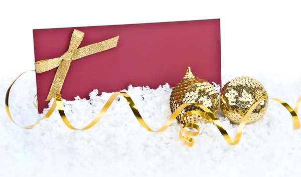 Різдвяні прикраси та вітальна листівка на сніговому фоні — стокове фото