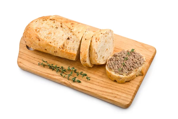 Segment van zelfgebakken brood met tapenade en kruiden op een houten snijden — Stockfoto