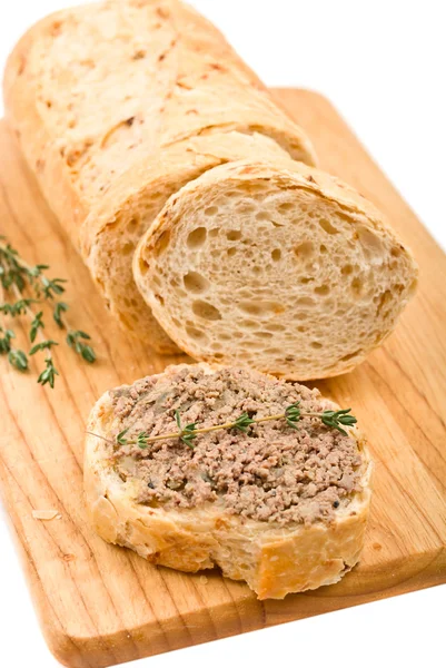 Scheibe hausgemachtes Brot mit Pastete und Kräutern auf einem Holzstück — Stockfoto
