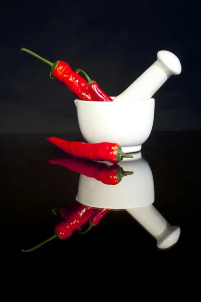Červené chilli papričky v třecí misce — Stock fotografie