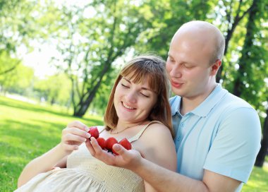 Genç çift parkta piknik yapıyor.