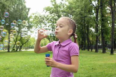 küçük kız parkta blowing bubbles