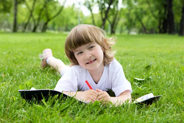 stock image Portrait of little girl reading a book in the park