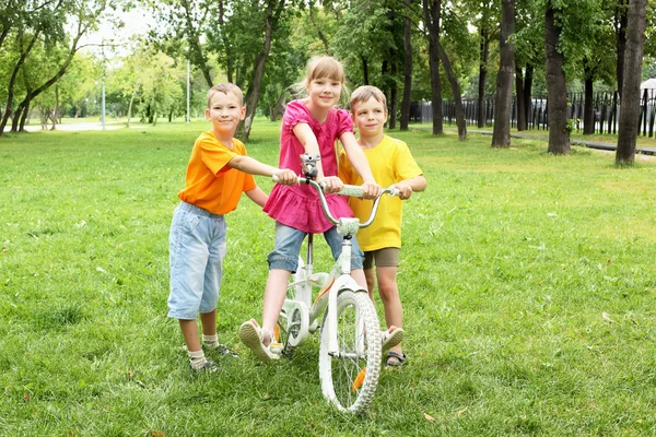 Τα κορίτσια με ένα ποδήλατο στο πάρκο — Φωτογραφία Αρχείου
