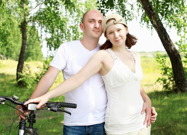 Jovem casal nas bicicletas no parque — Fotografia de Stock