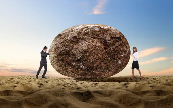 Empresario rodando una piedra gigante —  Fotos de Stock
