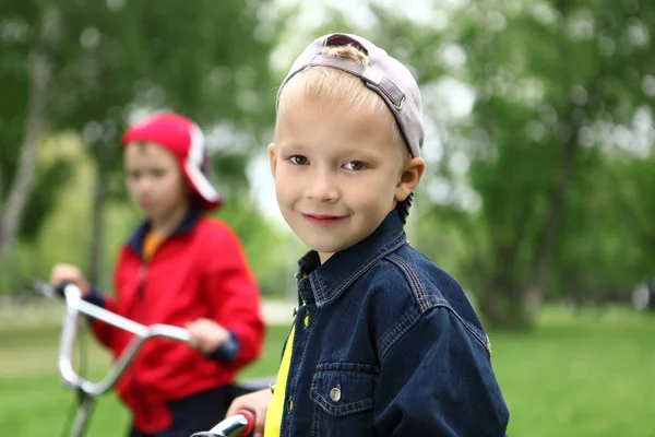 A kerékpár a zöld parkban fiú — Stock Fotó
