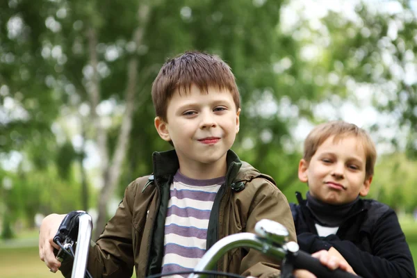 Jongen op een fiets in het groene park — Stockfoto