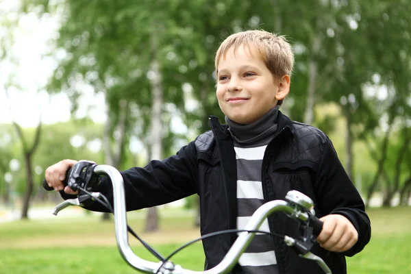 Niño en bicicleta en el parque verde — Foto de Stock