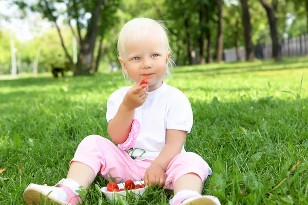 Liten flicka med jordgubbar utomhus — Stock fotografie