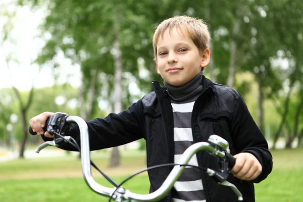 Niño en bicicleta en el parque verde — Foto de Stock