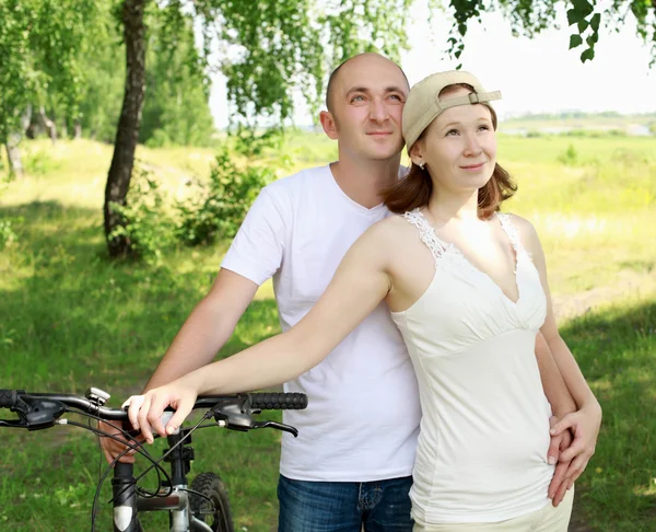 Mladý pár na kolech v parku — Stock fotografie