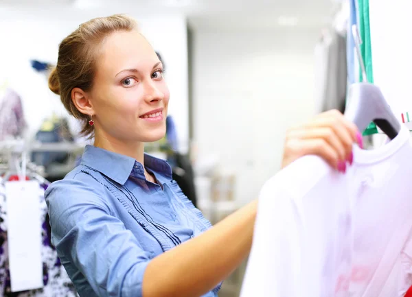 Kobieta w sklepie kupuje ubrania — Zdjęcie stockowe