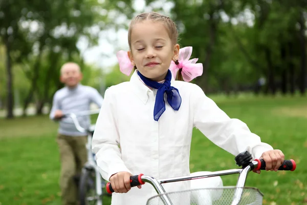 Дівчина на велосипеді в зеленому парку — стокове фото
