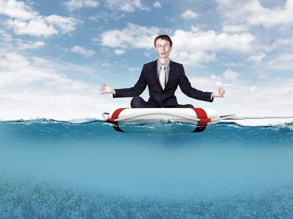 Businessman meditating on the rescue ring — Stock Photo, Image