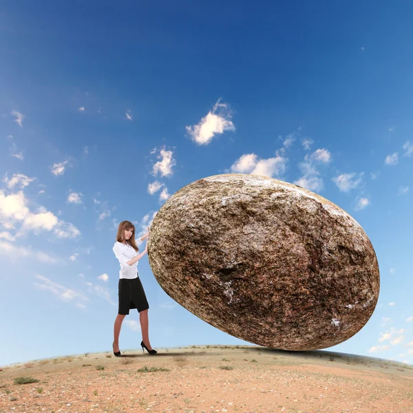 Zakenvrouw rollen een gigantische steen — Stockfoto