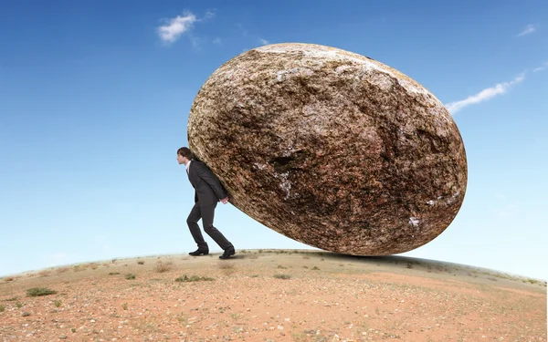 Affärsman rullande en gigantisk sten — Stockfoto