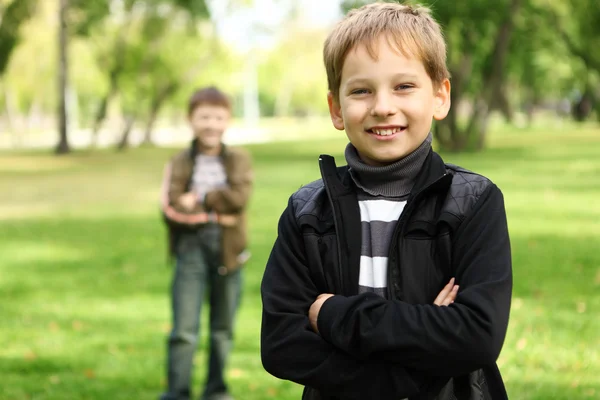 Chłopiec z kolegą w zielonym parku — Zdjęcie stockowe