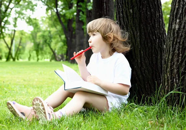 Portret dziewczynki, czytanie książki w parku — Zdjęcie stockowe