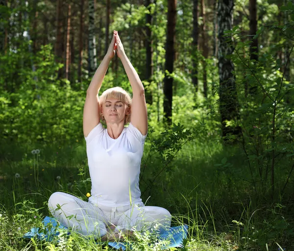 An elderly woman practices yoga — Stock Photo, Image