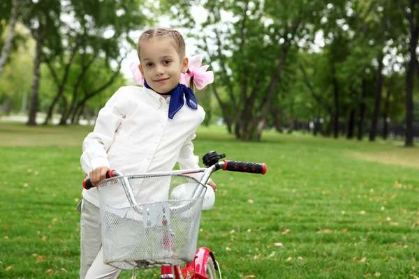 Lány a zöld parkban kerékpár — Stock Fotó