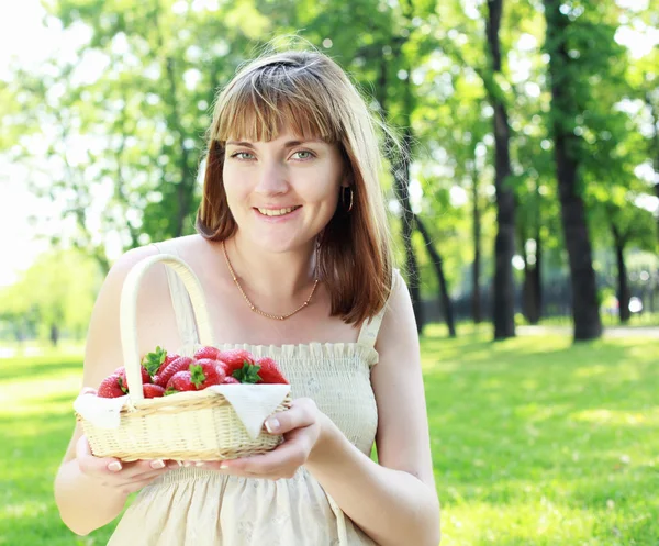 Młoda kobieta z truskawkami na zewnątrz — Zdjęcie stockowe