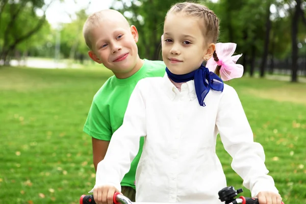 女孩骑着自行车在绿色公园 — 图库照片