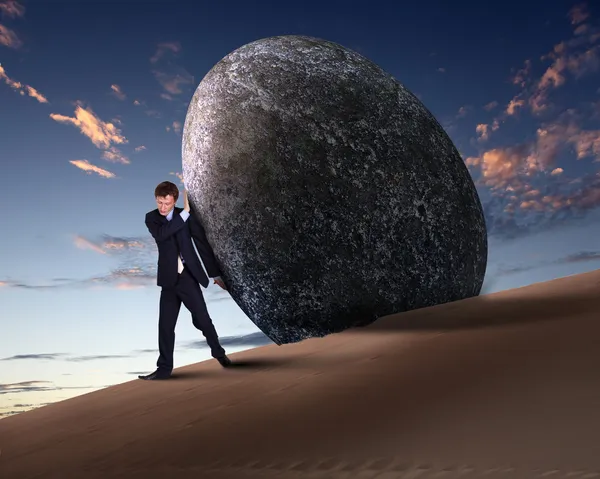 Affärsman rullande en gigantisk sten — Stockfoto