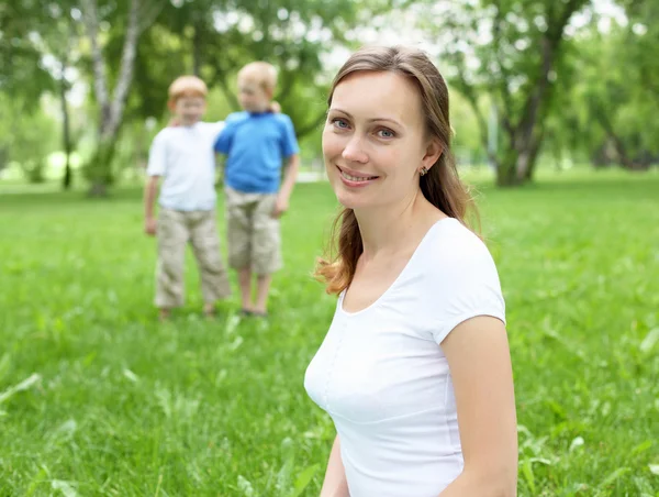 Porträt einer Mutter mit zwei Söhnen im Hintergrund — Stockfoto