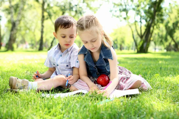Děti v parku, čtení knihy — Stock fotografie